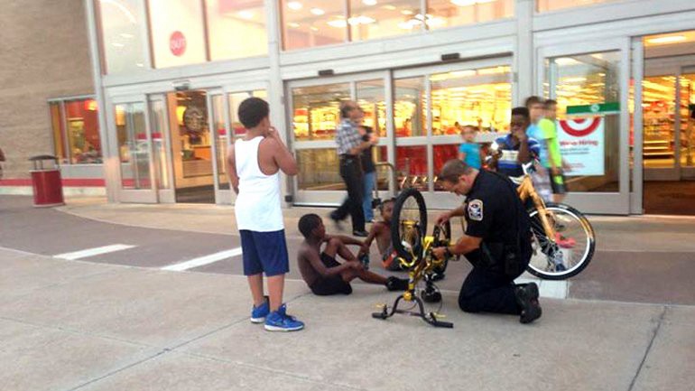 La foto que conmovió a EE.UU.: un policía le ayuda a arreglar la bici a un nene negro | Internacionales