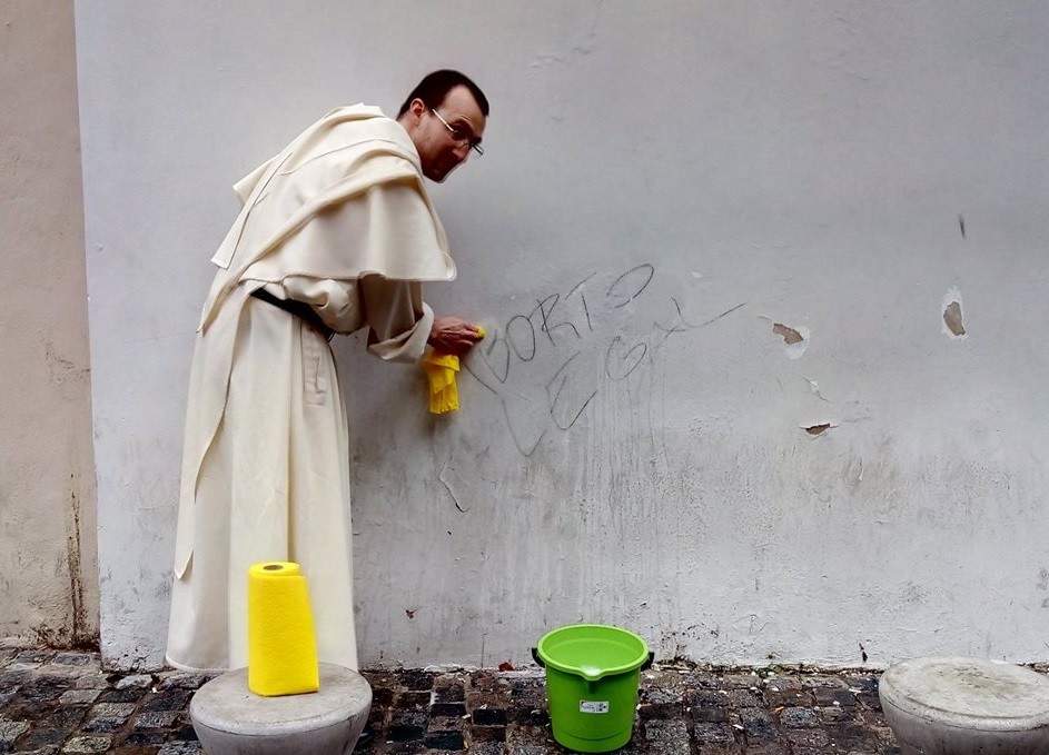 Aborto: La foto viral del sacerdote borrando pintada con trapo amarillo y balde verde | Redes