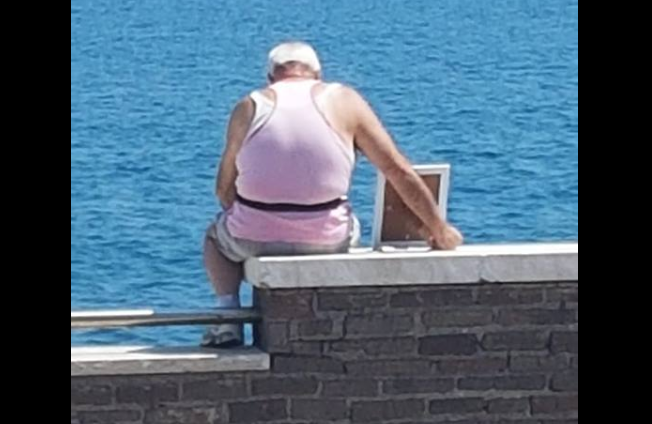 La foto de un hombre que mira al mar con un retrato de su esposa fallecida conmueve a todos en las redes | Redes