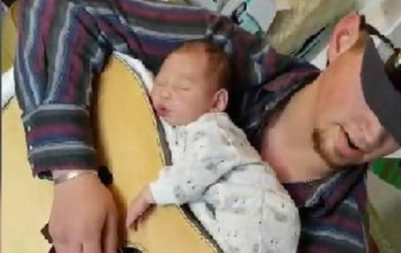 La forma más tierna para dormir a una bebé: arriba de la guitarra, mientras el padre toca | Redes