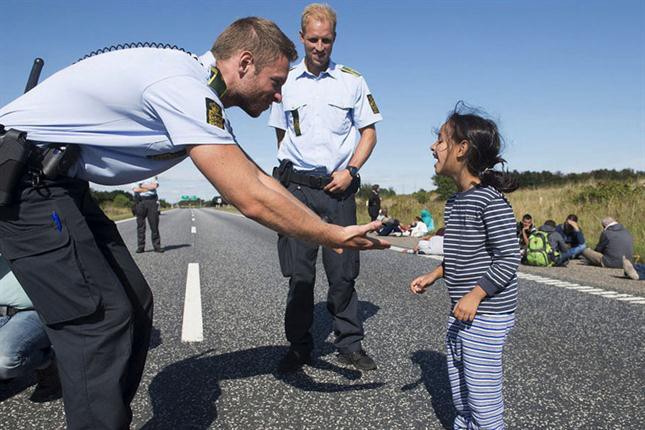 Risas y juegos entre una niña siria y un policía danés | Internacionales