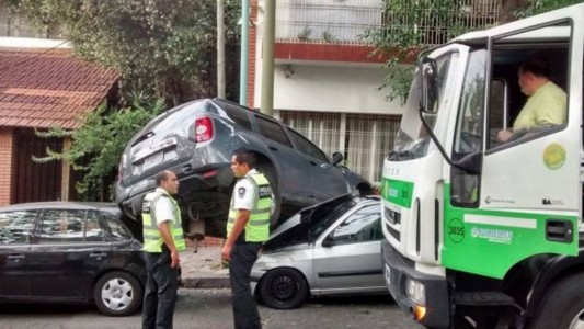 Un camión recolector chocó tres autos al intentar vaciar un contenedor