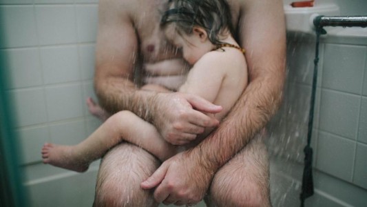 Un padre intentando aliviar a su hijo enfermo en la bañera, la foto censurada