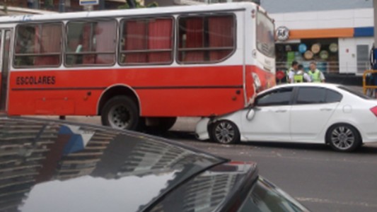 Un auto se incrustó debajo de un colectivo escolar