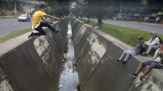 Video viral: el joven que intenta saltar un canal de agua en Bogotá