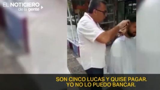 Como no puede pagar la luz, un peluquero corta el pelo en la vereda