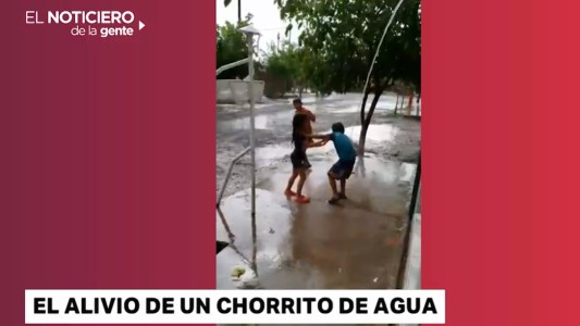 Ola de calor: nenes jugando bajo un chorro de agua