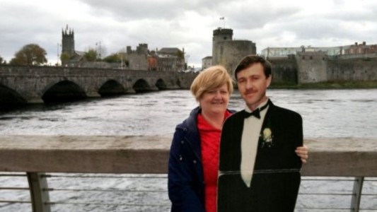 La historia de la viuda que viaja por el mundo con la figura de cartón de su esposo