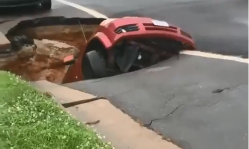 El momento en que un auto desaparece dentro de un enorme pozo