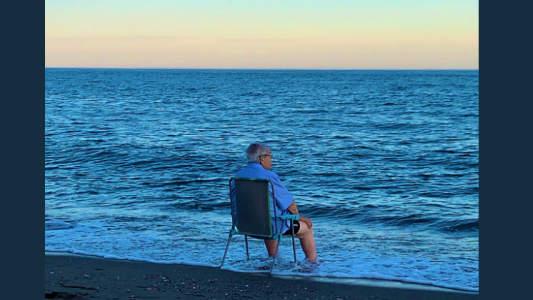 La historia detrás de la foto viral del anciano que llora sentado frente al mar