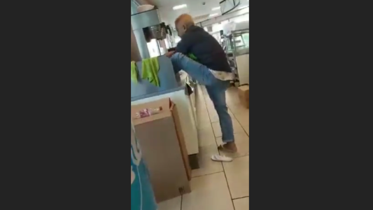 Empleado de cafetería se lava los pies en un lavamanos del mostrador
