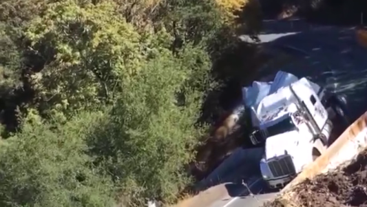 Camión dobla en una curva, vuelca y desbarranca