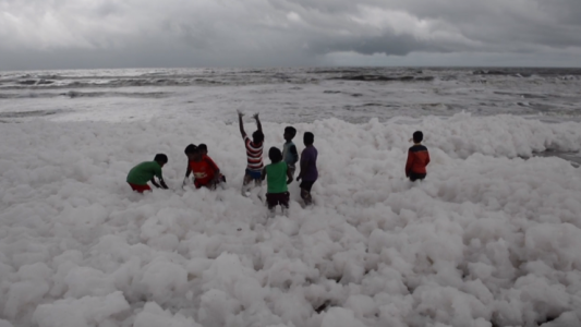 Estos niños juegan en la playa con espuma tóxica