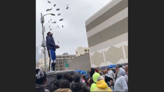 Polémica por rapero que arroja dólares a gente sin hogar desde el techo de su auto