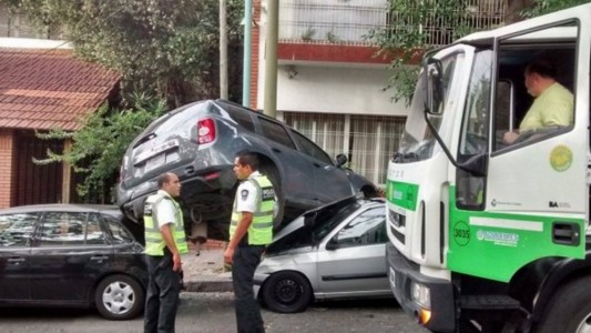 Un camión recolector chocó tres autos al intentar vaciar un contenedor