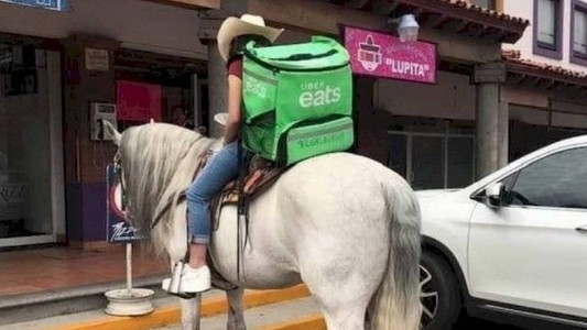 La foto viral de la chica que hace delivery arriba de un caballo blanco