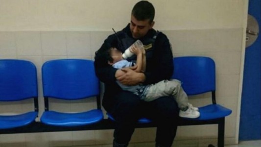 Foto viral: el policía que le da la mamadera a un nene descalzo