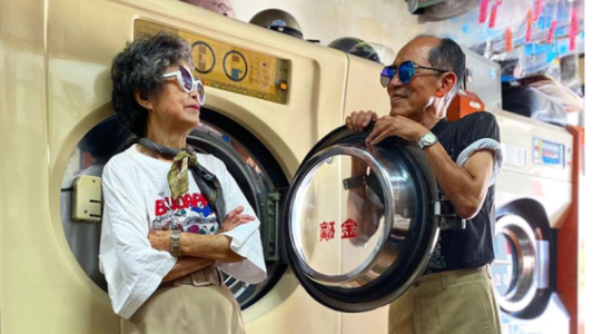 Una pareja se divierte modelando la ropa que se olvidan en su lavadero