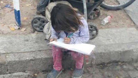 Foto conmovedora: la nena que hace la tarea de la escuela antes de pedir limosna en Tucumán