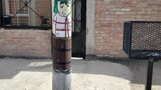 Pinta dibujos en los postes de luz para embellecer el barrio con recuerdos de la infancia