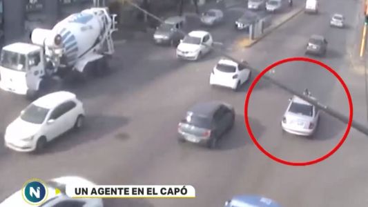 Para evitar una multa, arrastró a un agente de tránsito en el capot