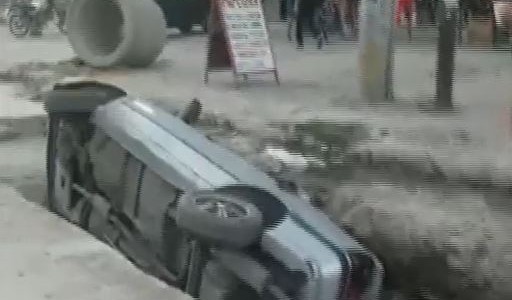 Un auto volcó y cayó en un pozo