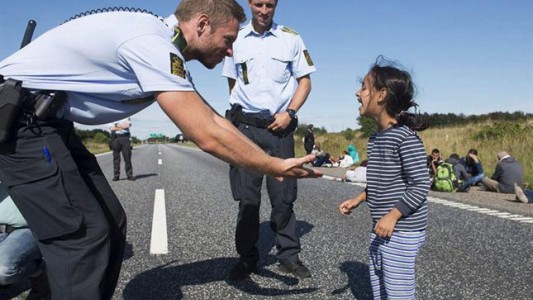 Risas y juegos entre una niña siria y un policía danés