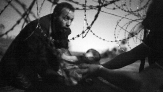 Un papá refugiado tratando de salvar a su bebé, la mejor foto del año