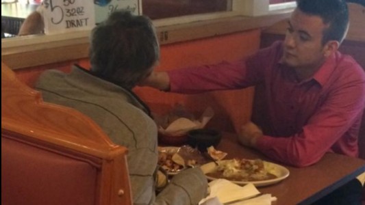#EsViral El mozo que ayuda a comer a un hombre sin manos