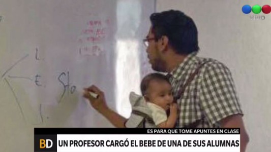 Un profesor con el bebé de su alumna para que ella pueda tomar apuntes