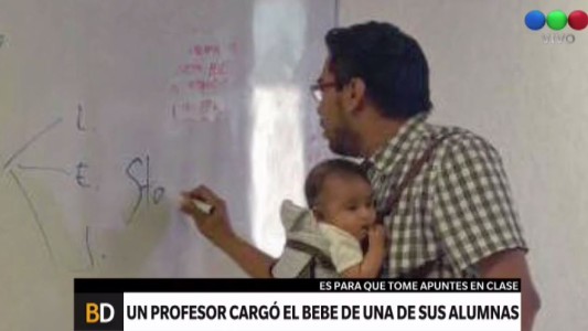 Un profesor con el bebé de su alumna para que ella pueda tomar apuntes