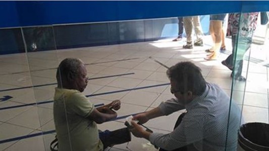 El gerente de un banco se sentó en el piso para atender a un cliente discapacitado y la imagen explotó en las redes sociales