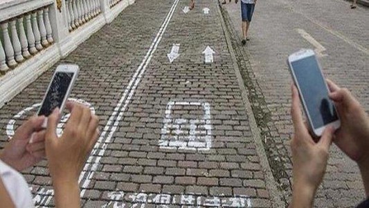 Crearon el carril "cabezas agachadas", exclusivo para peatones con celular