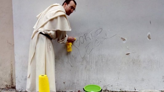 Aborto: La foto viral del sacerdote borrando pintada con trapo amarillo y balde verde