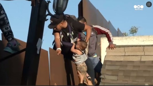 Dramáticas imágenes de una familia con niños trepando el muro para cruzar la frontera hacia EE UU