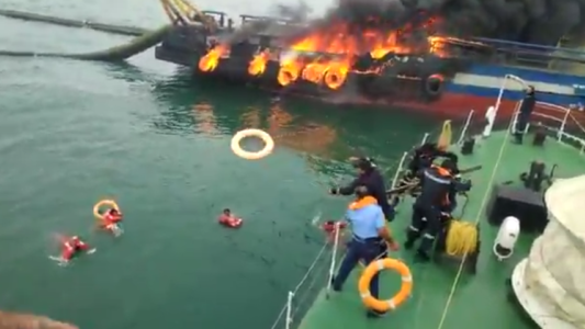 La tripulación salta al agua para salvarse de un incendio en un buque