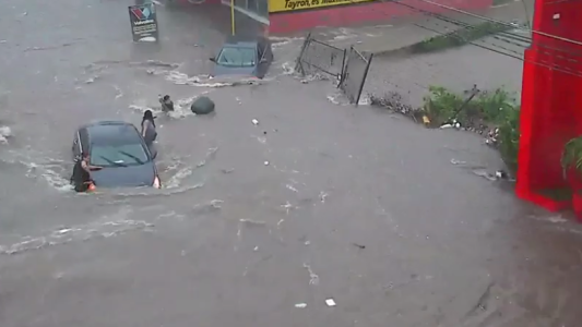 Se bajó en medio de la inundación y se la "tragó" una alcantarilla