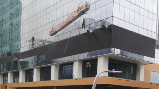 Limpiaban los vidrios de un edificio y el viento descontroló el andamio