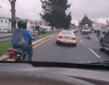 Un motociclista patea un auto, se cae y se salva de ser atropellado