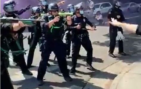 Un policía dispara a una mujer que le pide bajar el arma durante una protesta