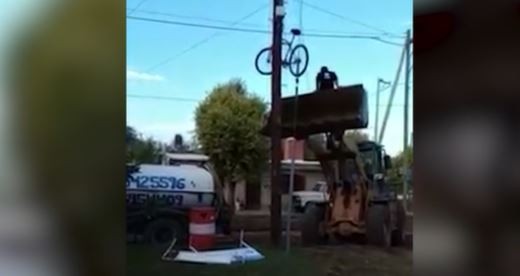 Video: con una pala mecánica, un obrero cuelga su bicicleta en un poste de luz para que no se la roben