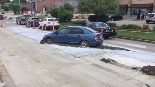 Su auto quedó atrapado en cemento por no esperar el avance de autos en el tránsito
